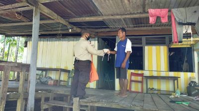 Bhabinkamtibmas Holtekamp Bagikan Masker Ke Rumah-rumah Warga